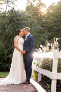 Bride and groom kissing near Wheeler House fence